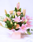 pink lilies and pink roses in a flower box