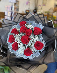 Bouquet of red roses with white accents in a floral shop setting